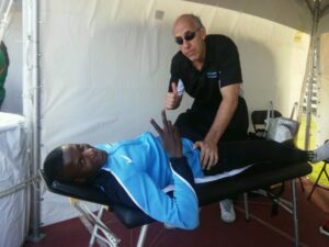 At the World Relays, Dr. Claussen treats a member of the Men's Botswana team prior to a 4 x 400m Silver Medal performance.